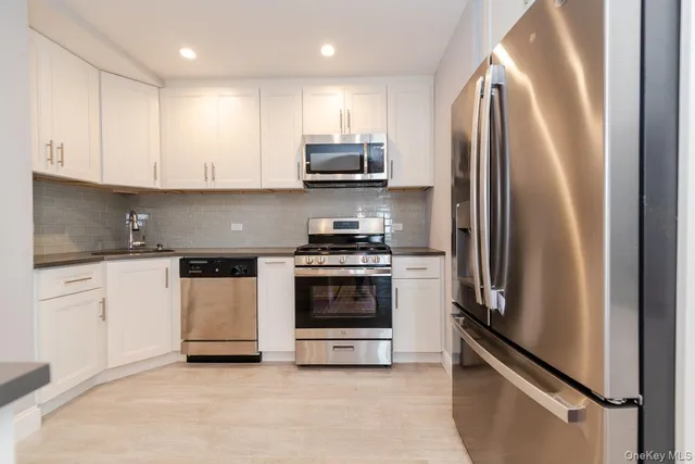 a kitchen with stainless steel appliances granite countertop a refrigerator sink and stove