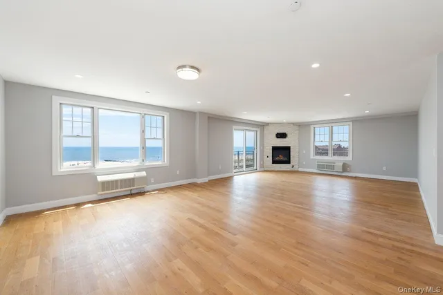a view of empty room with wooden floor and fireplace