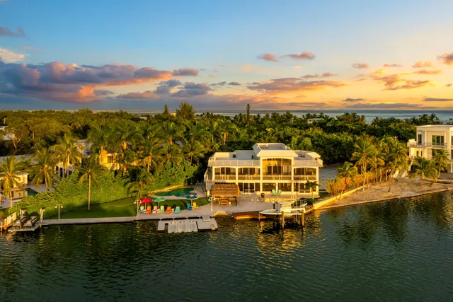 a kitchen with stainless steel appliances kitchen island granite countertop a table chairs microwave and cabinets