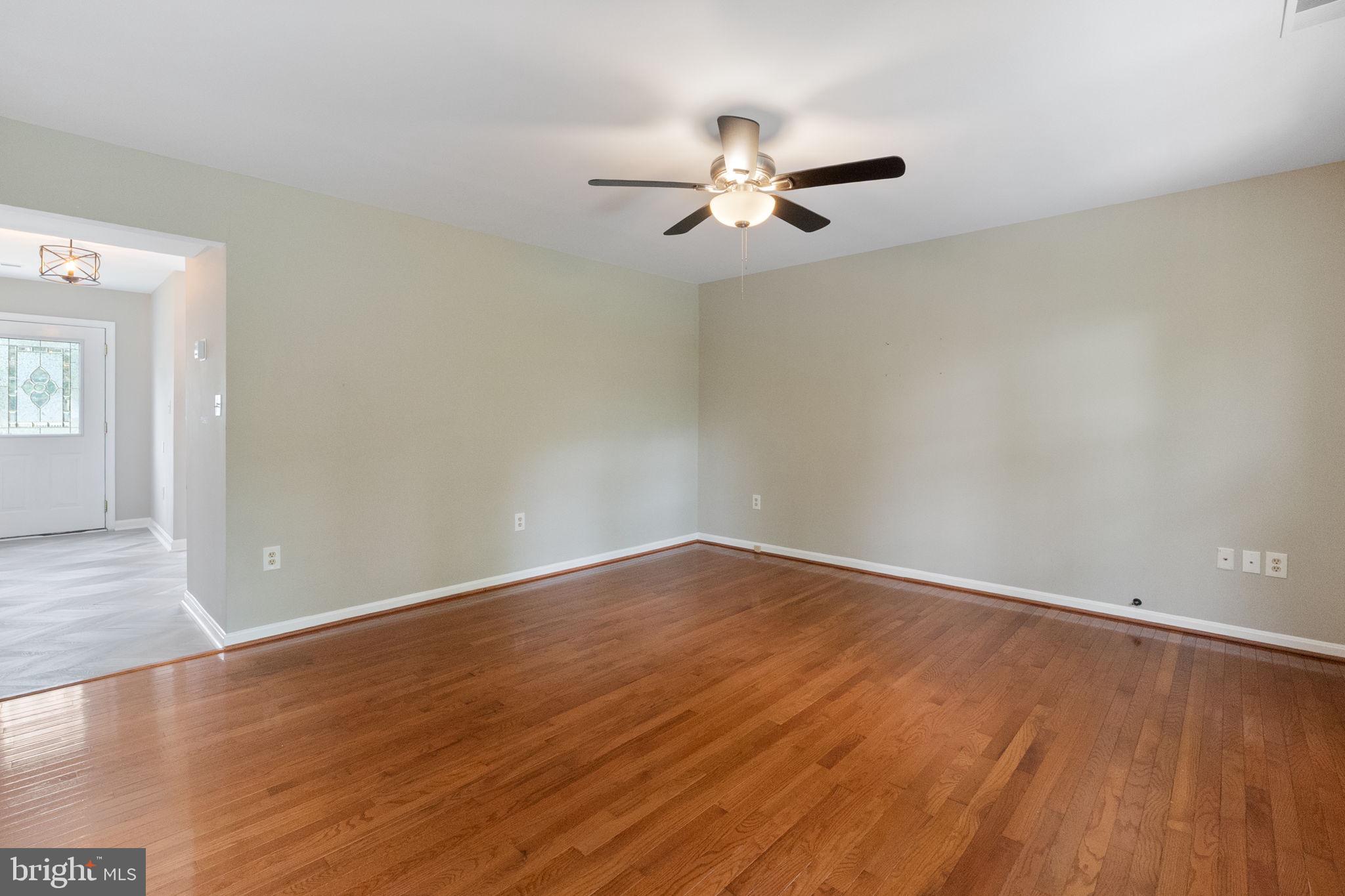 1527 Lincoln Road Shady Side, MD 20764 - Photo 7 of 30 an empty room with wooden floor fan and windows