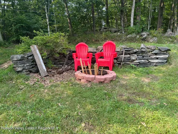 a view of a wooden chairs and fire pit in the backyard