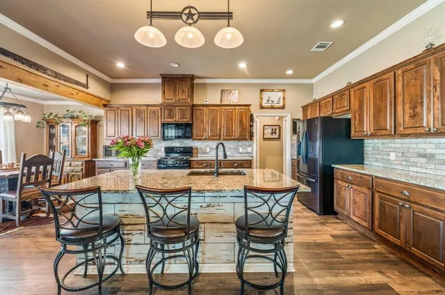 a kitchen with stainless steel appliances a table chairs and a refrigerator
