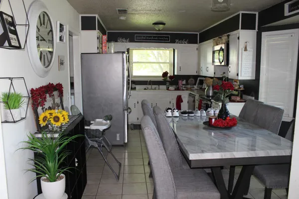 a dining room with furniture potted plants and wooden floor