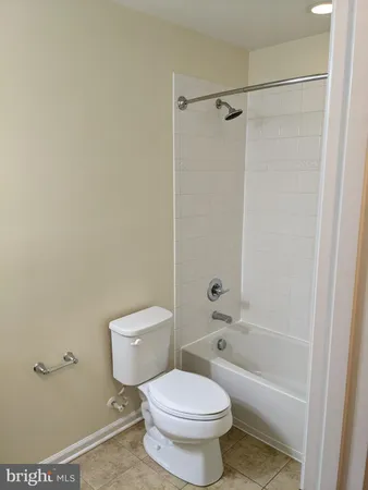 a white toilet sitting next to a bath tub