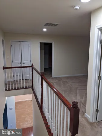 a view of a hallway with wooden floor and staircase
