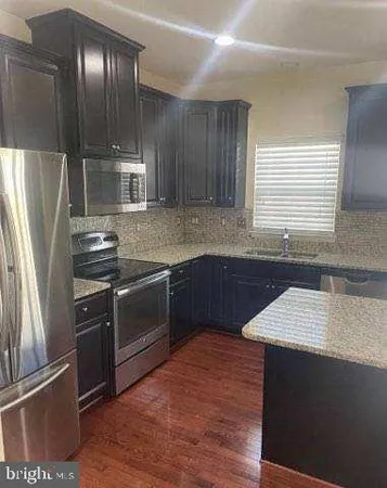 a kitchen with granite countertop stainless steel appliances and wooden cabinets