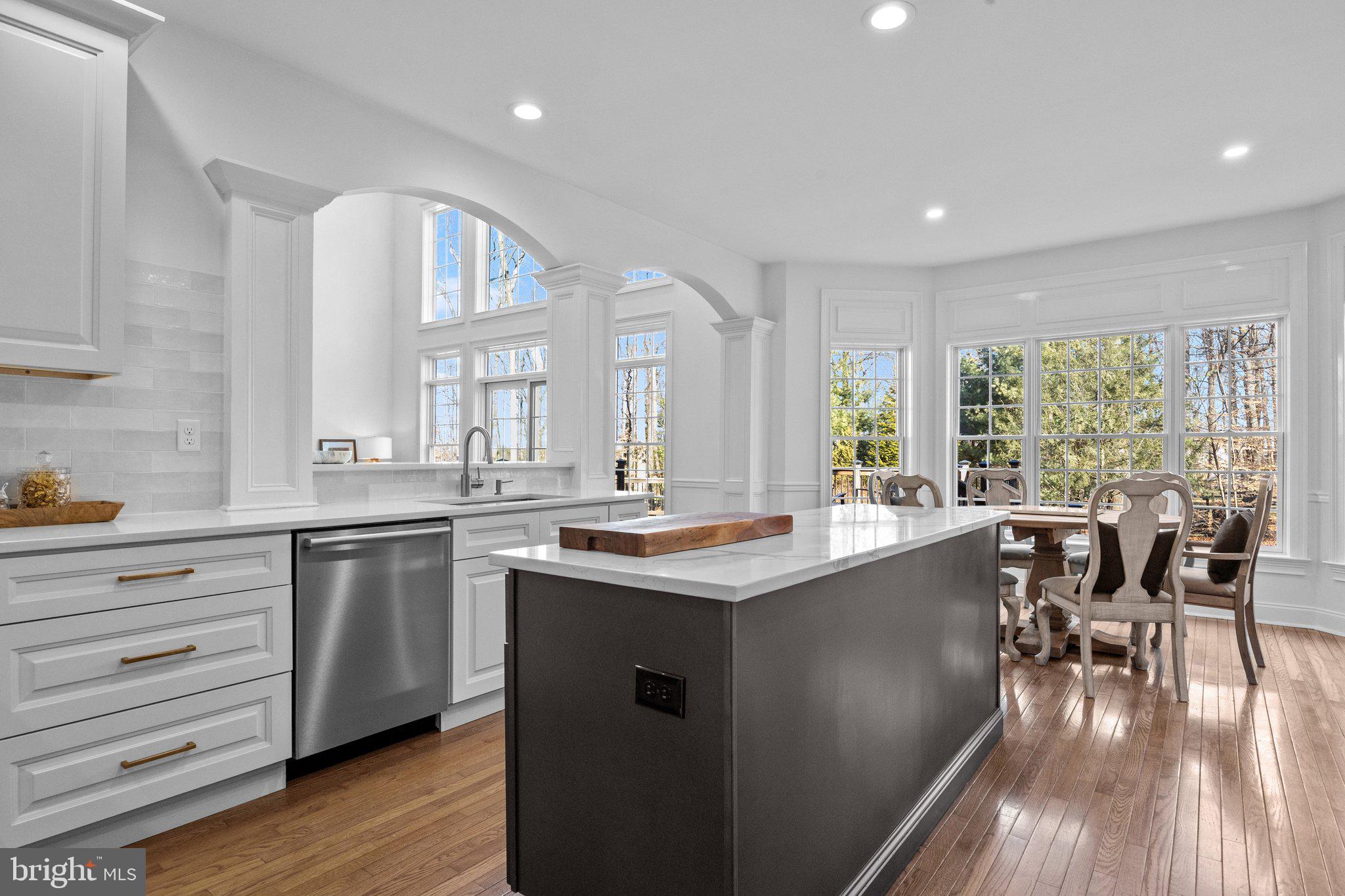 3216 Aquetong Road Doylestown, PA 18902 - Photo 14 of 54 a kitchen with stainless steel appliances granite countertop hardwood floor sink stove dining table chairs and wooden cabinets