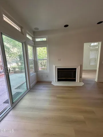 a view of an empty room with a fireplace and a window
