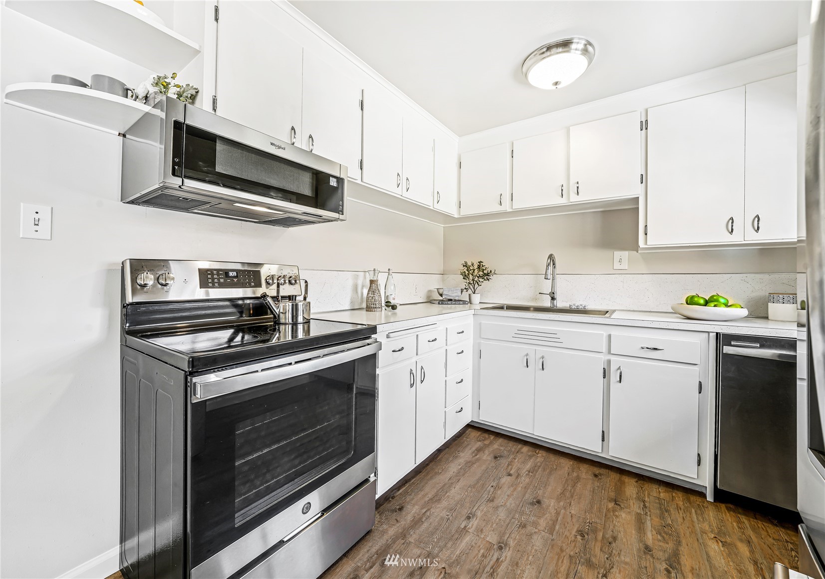 3908 Northeast 22nd Street Renton, WA 98056 - Photo 8 of 32 a kitchen with stainless steel appliances white cabinets granite counter tops and a hard wood floors