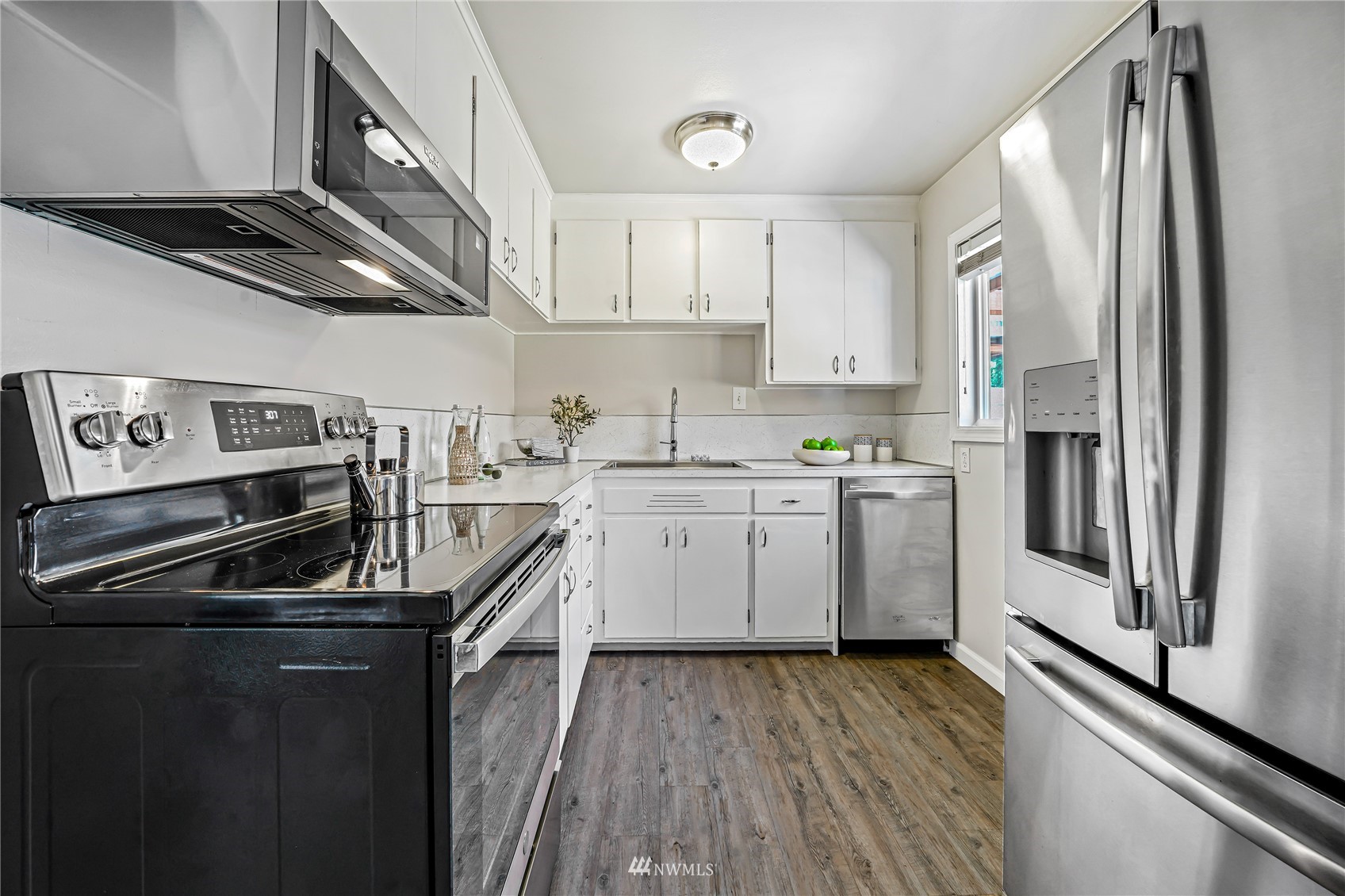 3908 Northeast 22nd Street Renton, WA 98056 - Photo 9 of 32 a kitchen with cabinets stainless steel appliances a sink and wooden floor