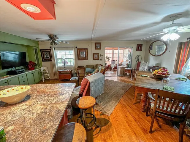 a living room with furniture a flat screen tv and kitchen view