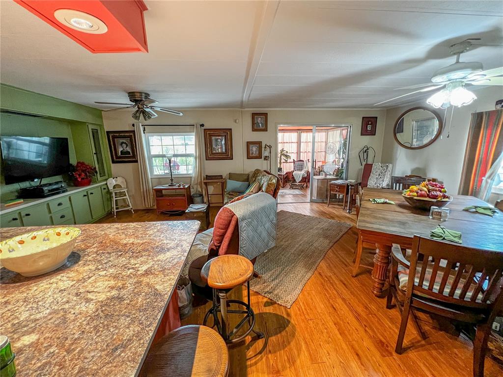 34543 Rosebud Row Zephyrhills, FL 33541 - Photo 13 of 41 a living room with furniture a flat screen tv and kitchen view