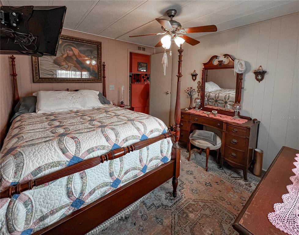 34543 Rosebud Row Zephyrhills, FL 33541 - Photo 16 of 41 a bedroom with a bed and a chandelier