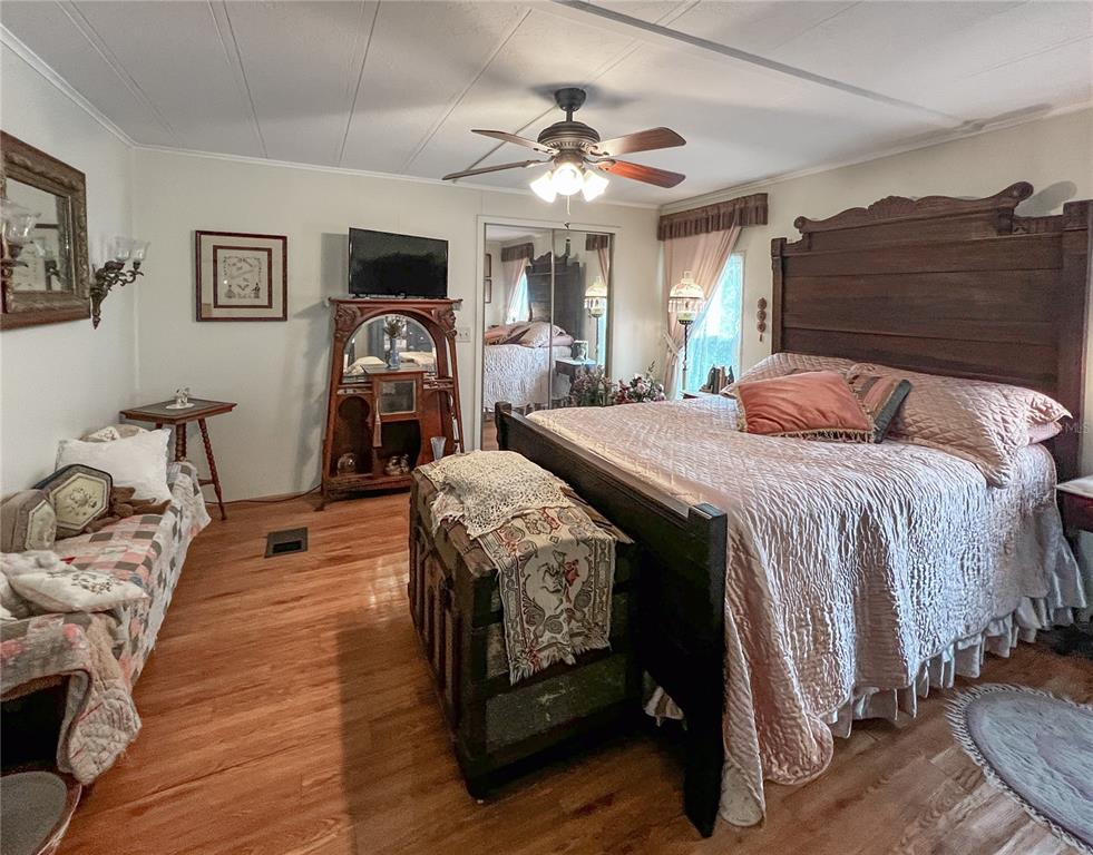 34543 Rosebud Row Zephyrhills, FL 33541 - Photo 20 of 41 a bedroom with a bed and wooden floor