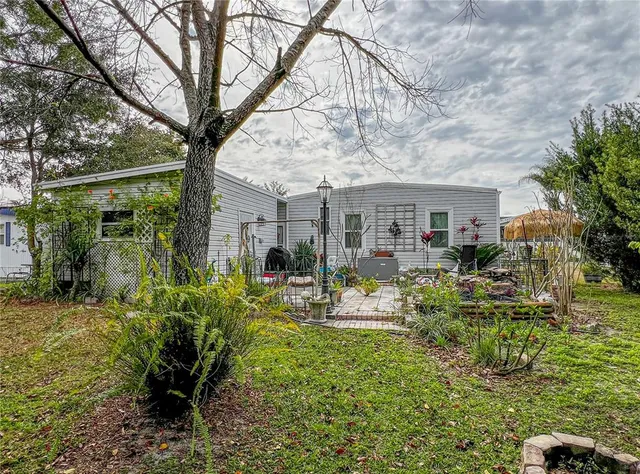 a view of a house with backyard and sitting area
