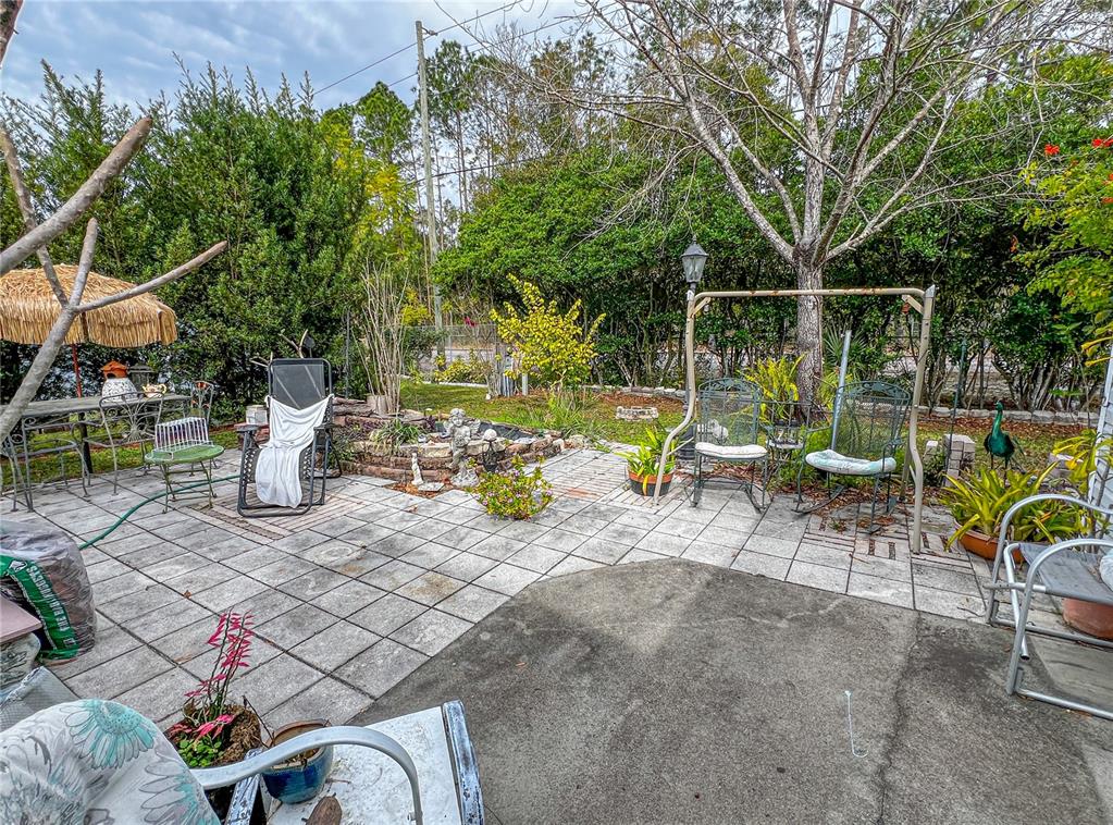34543 Rosebud Row Zephyrhills, FL 33541 - Photo 38 of 41 a view of a chairs and table in backyard