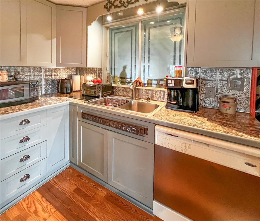 34543 Rosebud Row Zephyrhills, FL 33541 - Photo 10 of 41 a kitchen with stainless steel appliances granite countertop a sink a stove and cabinets