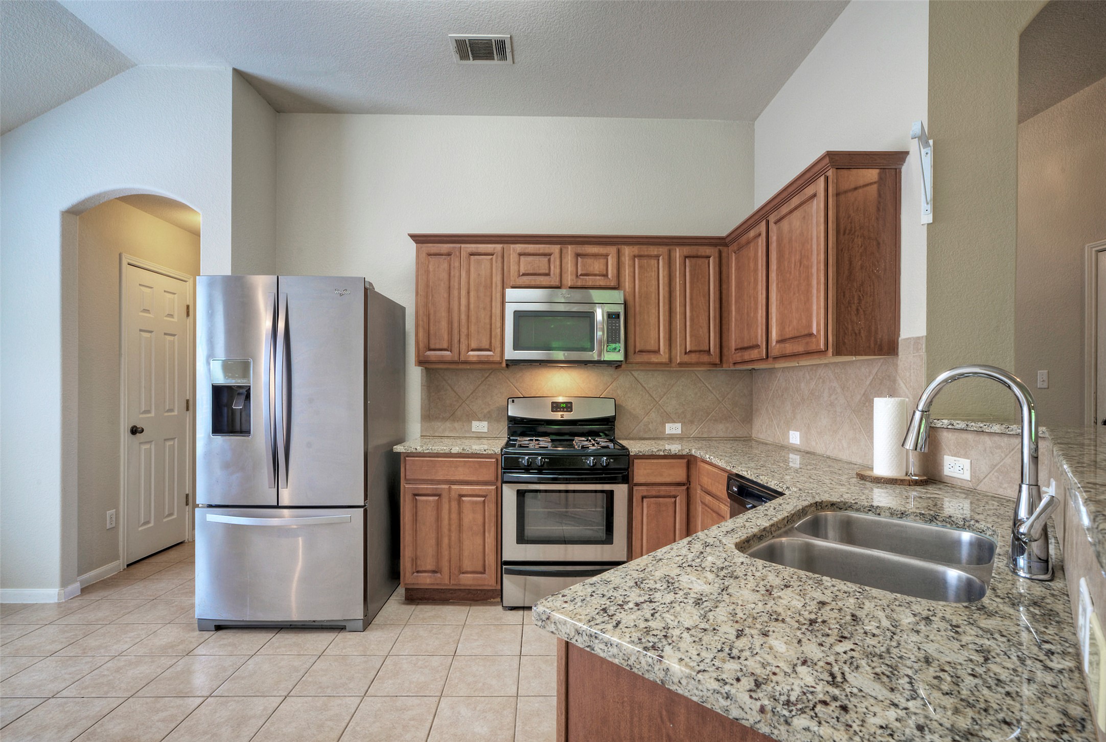 400 Pheasant Ridge Drive Round Rock, TX 78665 - Photo 19 of 29 Kitchen featuring light-toned tile flooring and L-shaped counters