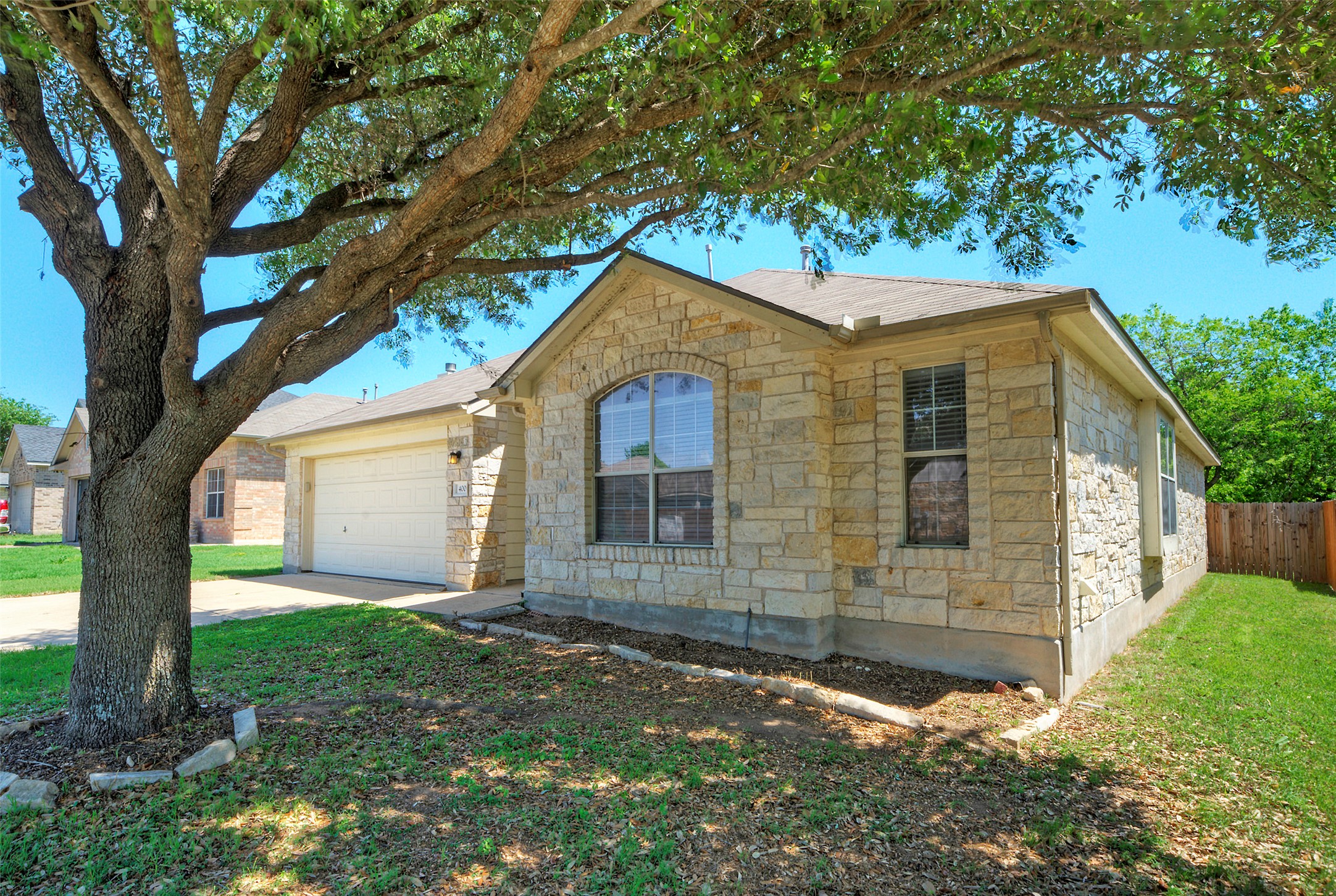 400 Pheasant Ridge Drive Round Rock, TX 78665 - Photo 2 of 29 Single-story stone exterior featuring an arched window, attached garage, and a fenced side yard