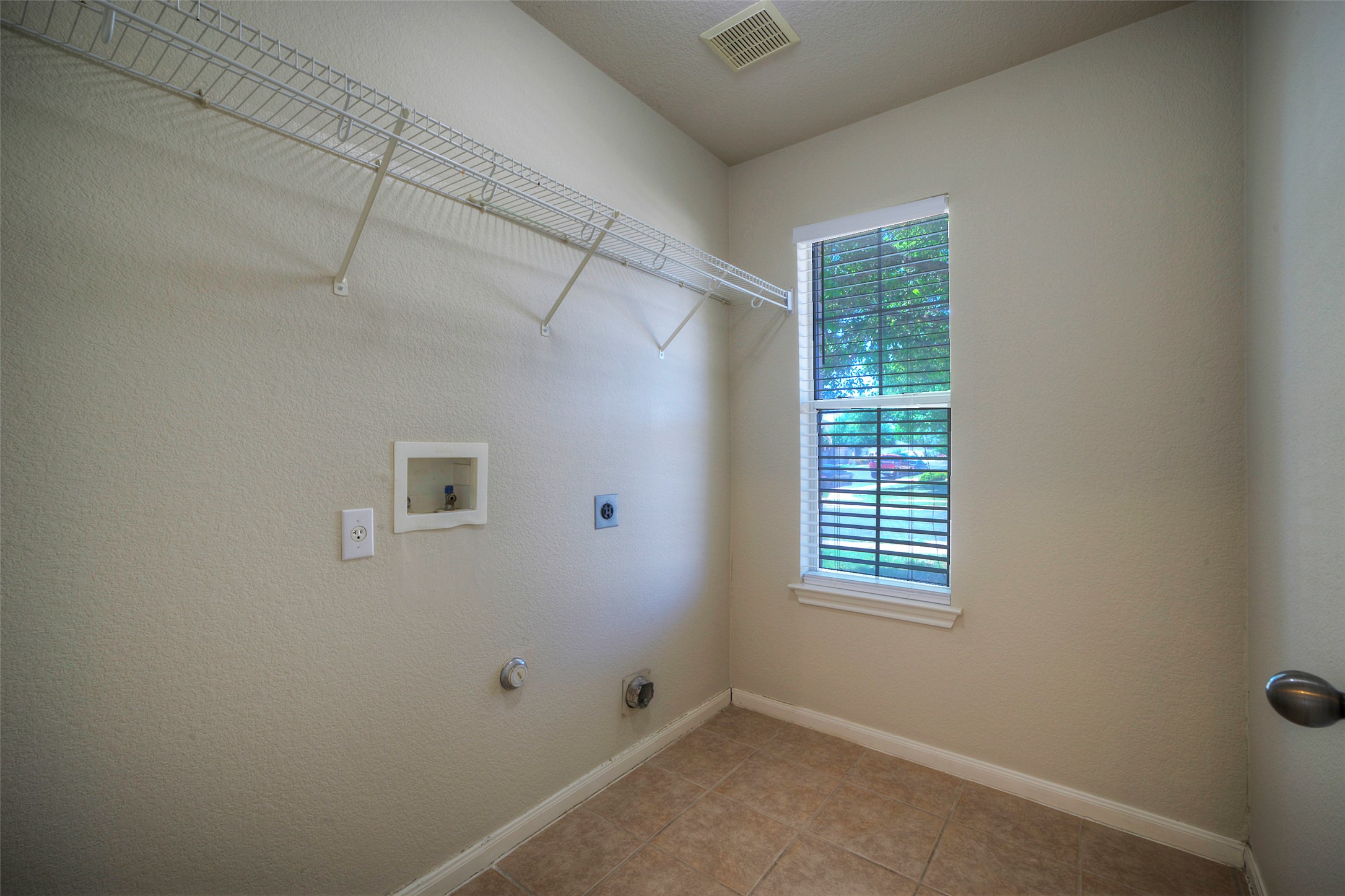 400 Pheasant Ridge Drive Round Rock, TX 78665 - Photo 22 of 29 Dedicated laundry room featuring wire shelving, a single window with blinds, and tile flooring