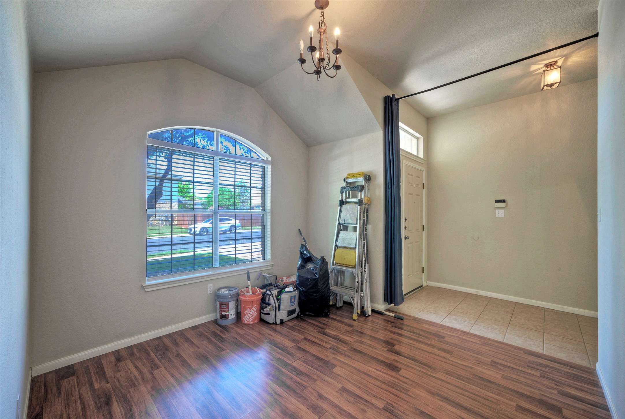 400 Pheasant Ridge Drive Round Rock, TX 78665 - Photo 23 of 29 Vaulted ceiling room featuring an arched window, wood-finish flooring, and a chandelier light fixture