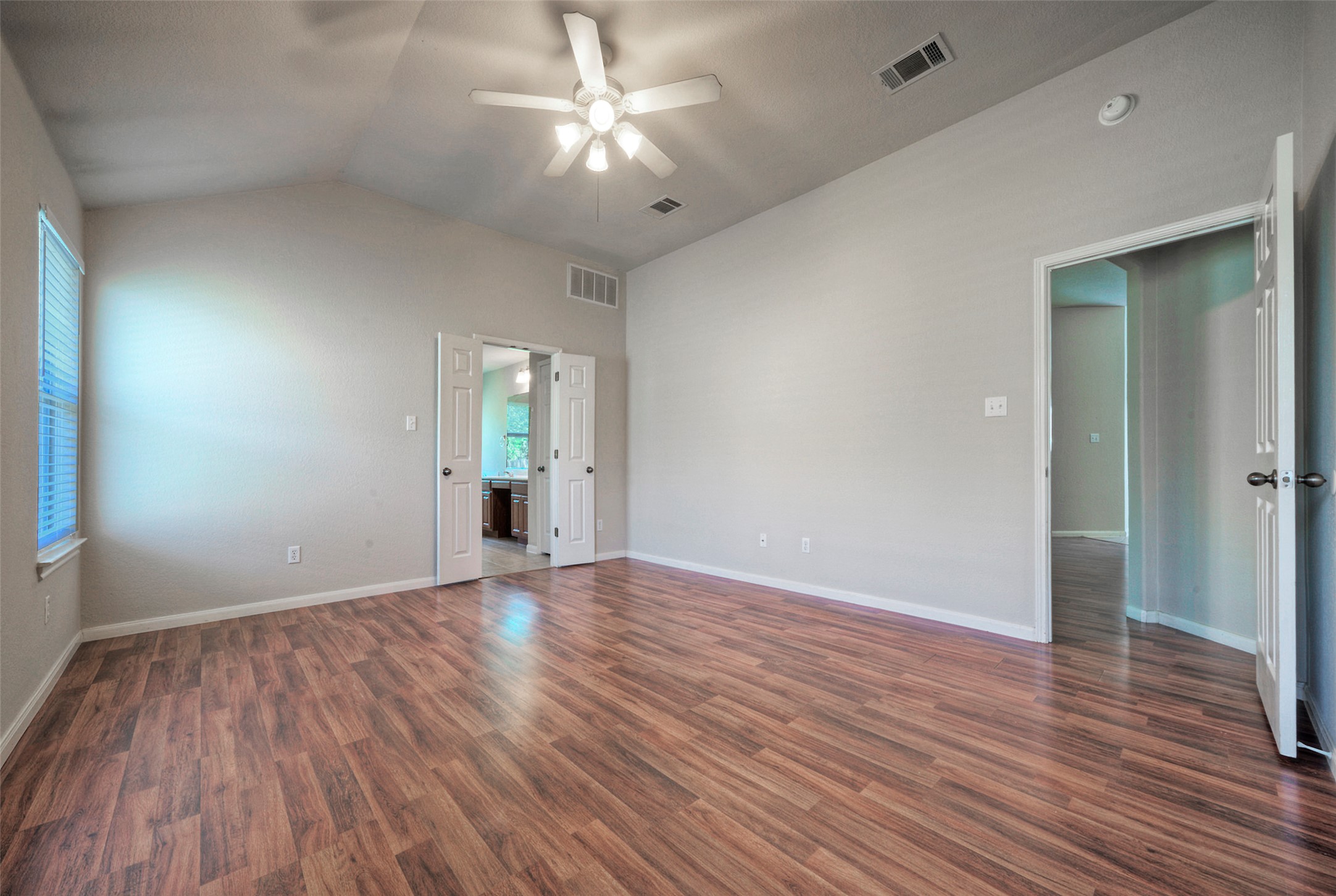 400 Pheasant Ridge Drive Round Rock, TX 78665 - Photo 25 of 29 Spacious room featuring vaulted ceilings, wood-finish flooring, a ceiling fan with integrated lighting, and multiple entry points including a double door