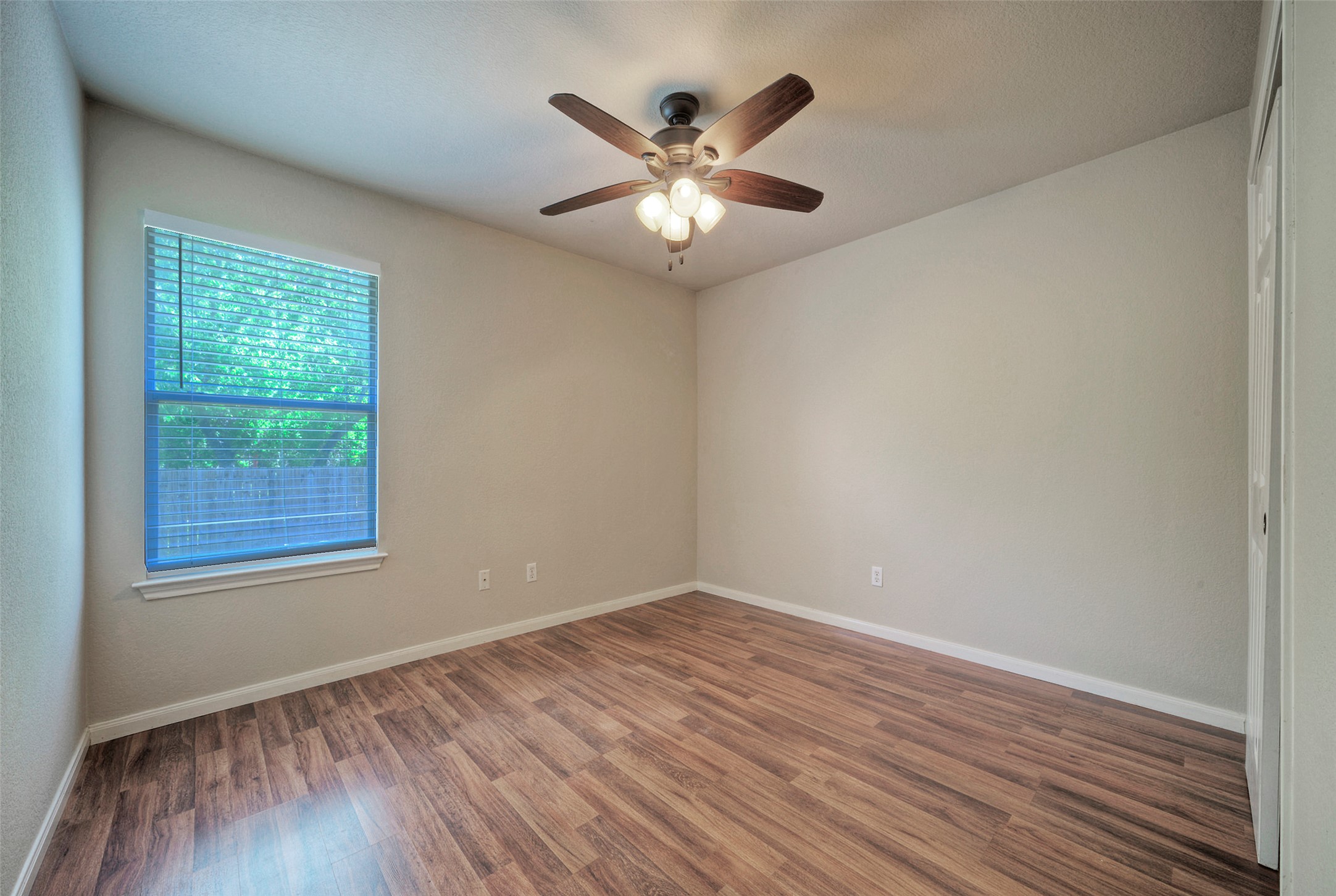 400 Pheasant Ridge Drive Round Rock, TX 78665 - Photo 28 of 29 Room featuring wood-finish flooring, a window with blinds, a ceiling fan with light fixture, and neutral wall tones