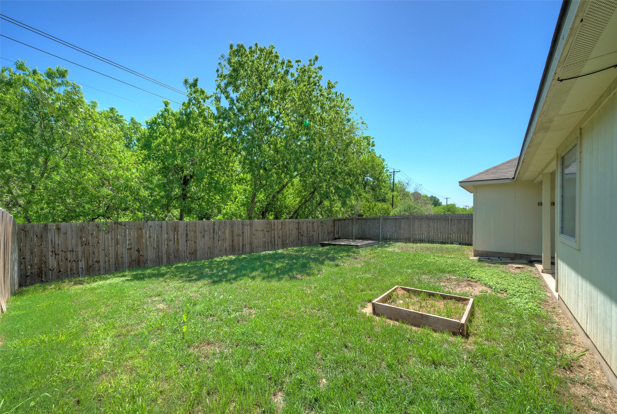 400 Pheasant Ridge Drive Round Rock, TX 78665 - Photo 4 of 29 Expansive backyard featuring a wood privacy fence, mature perimeter trees, and a ground-level planter box