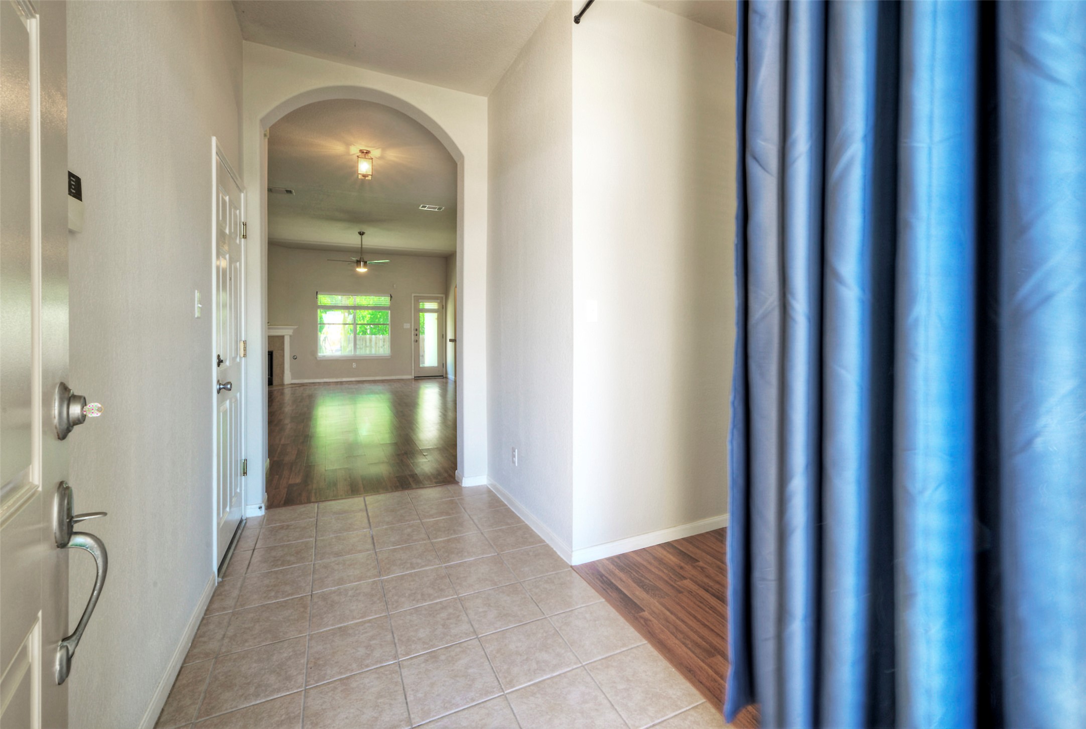 400 Pheasant Ridge Drive Round Rock, TX 78665 - Photo 7 of 29 Foyer entry with tile flooring opening to a spacious room featuring wood-finish flooring, a ceiling fan, and large windows