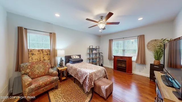 a bedroom with a bed a couch and a flat tv screen on the dresser