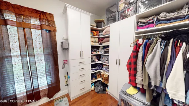 a view of walk in closet with clothes and shoes