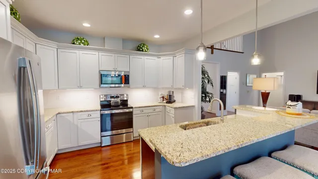 a kitchen with stainless steel appliances granite countertop a sink refrigerator and microwave