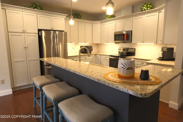 a kitchen with stainless steel appliances granite countertop a sink refrigerator and microwave