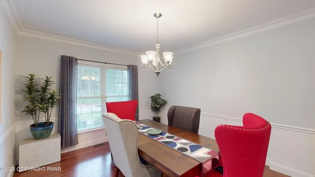 a dining room with furniture potted plants and wooden floor