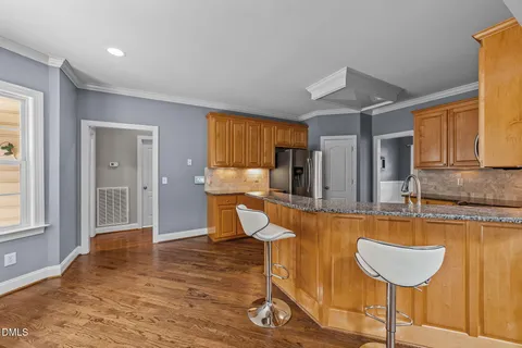a kitchen with stainless steel appliances granite countertop a refrigerator and a stove top oven