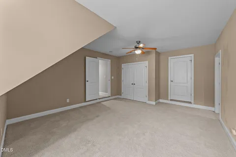 a view of an empty room with a ceiling fan
