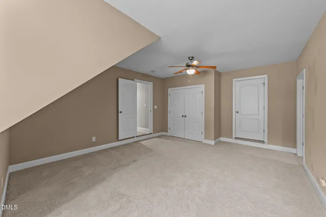 a view of an empty room with a ceiling fan