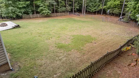a view of a yard with wooden fence