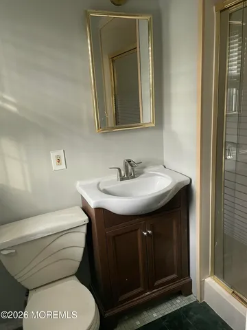 a bathroom with a toilet a sink and a mirror
