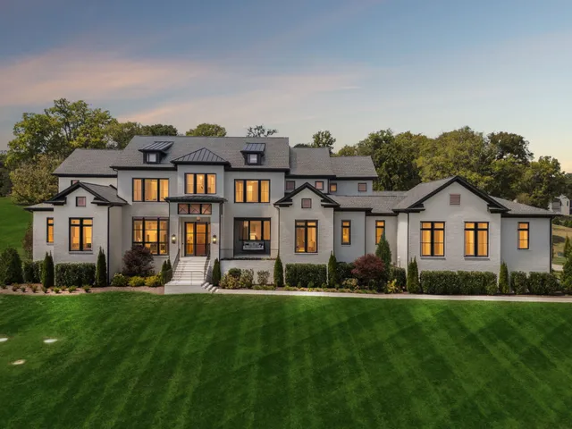 a front view of a house with a yard and trees