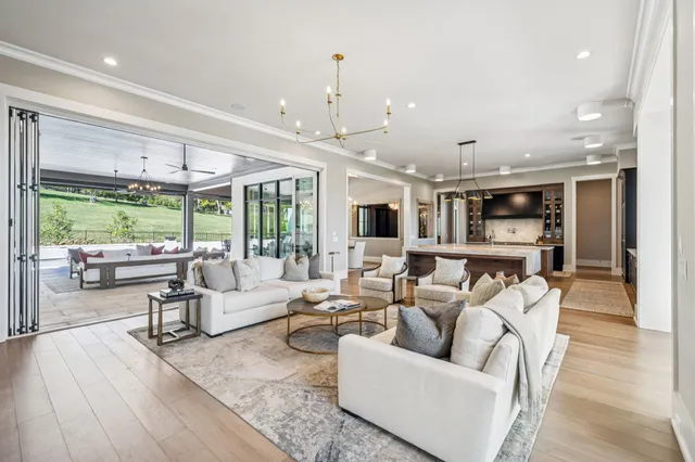 a large kitchen with stainless steel appliances a stove a sink dishwasher and a dining table with the view of kitchen