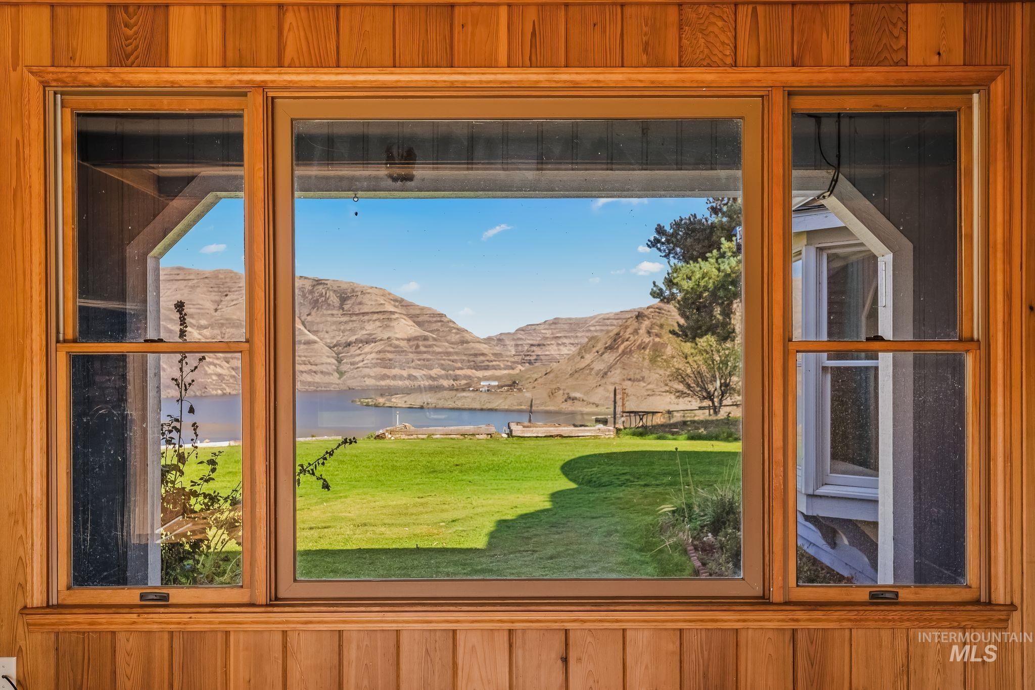 531 Silcott Road Clarkston, WA 99403 - Photo 18 of 43 Wood paneling and trim framing a window overlooking a body of water and distant hills