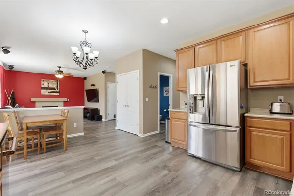 a kitchen with stainless steel appliances granite countertop a refrigerator oven a stove a dining table and chairs with wooden floor