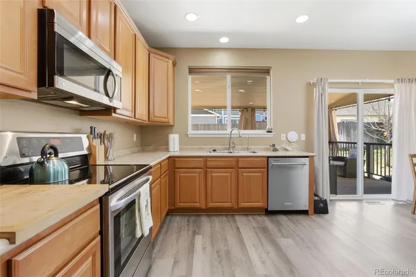 a kitchen with stainless steel appliances granite countertop a sink and wooden cabinets