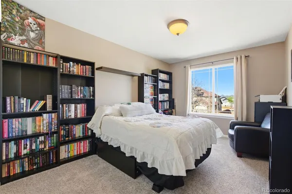 a bedroom with a bed furniture and a book shelf