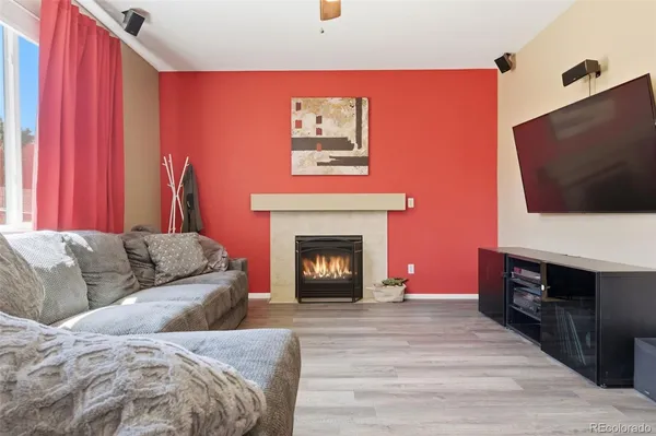 a living room with furniture a flat screen tv and a fireplace