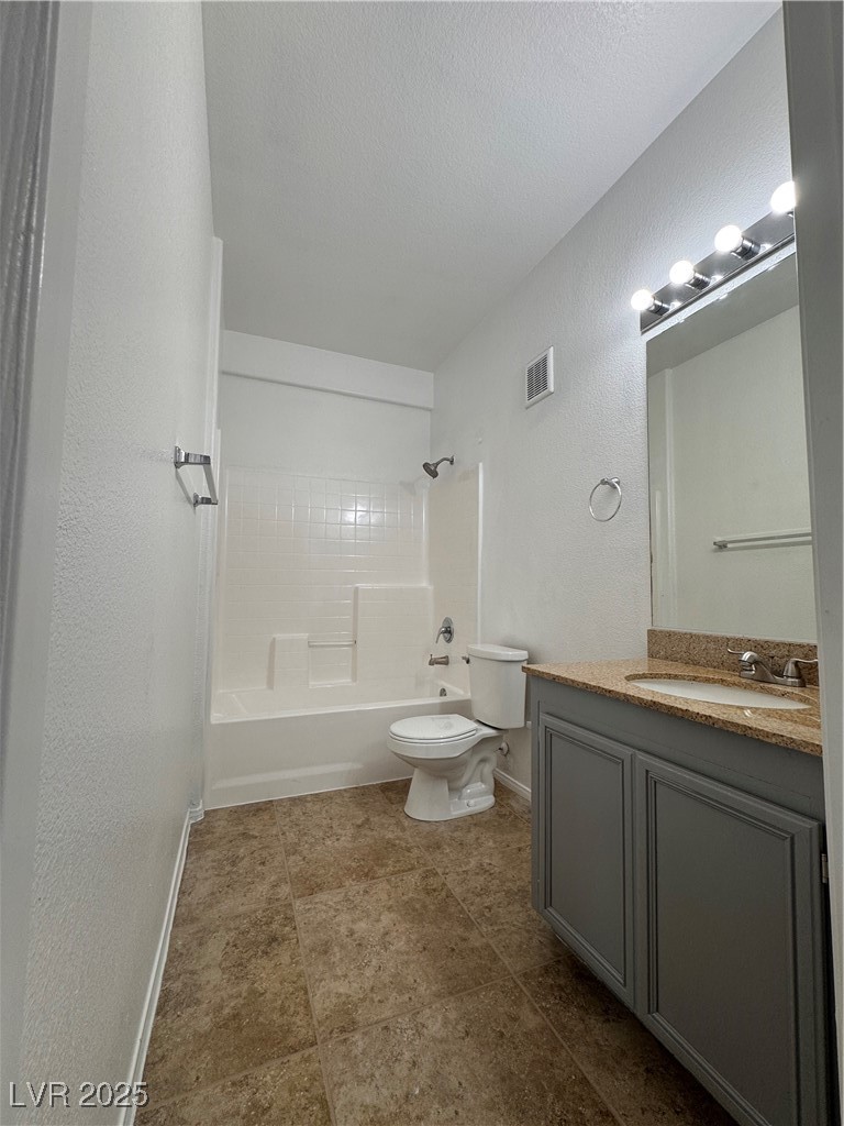 9975 Peace Way, Unit 1140 Las Vegas, NV 89147 - Photo 9 of 23 Full bathroom with a textured wall, visible vents, toilet, baseboards, and bathtub / shower combination