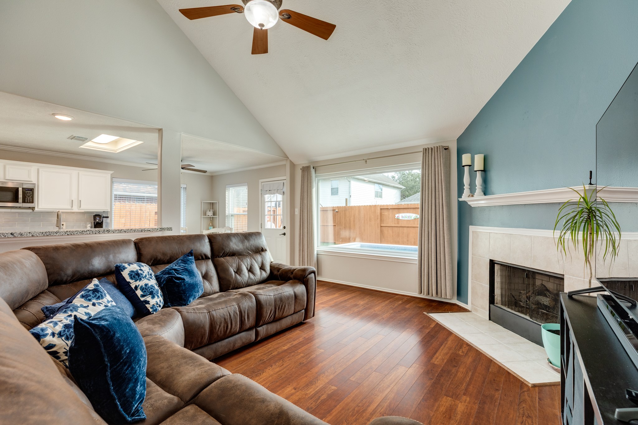 4113 Merlet Drive Pearland, TX 77584 - Photo 8 of 36 Large family room with a gas log fireplace and a large window overlooking the backyard oasis. This space is perfect for family gatherings and enjoying the outdoors.