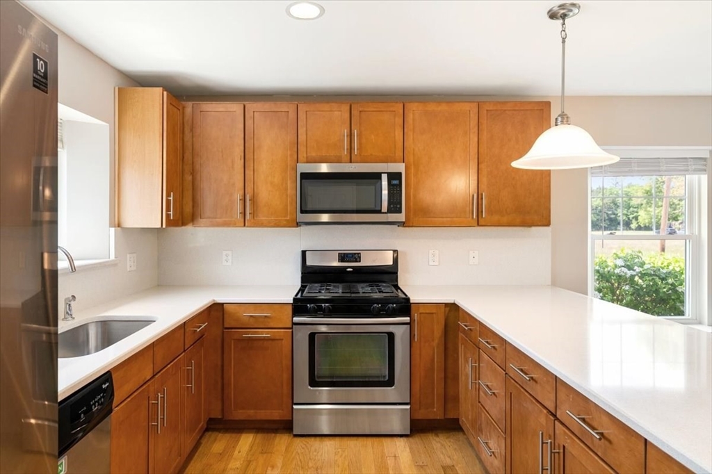 6 Bates Street, Unit A Devens, MA 01434 - Photo 19 of 41 a kitchen with a stove a sink and a microwave