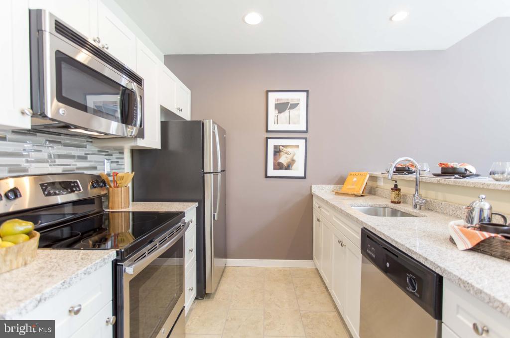 1900-20 Arch Street, Unit 1214 Philadelphia, PA 19103 - Photo 3 of 30 a kitchen with stainless steel appliances granite countertop a sink stove and refrigerator